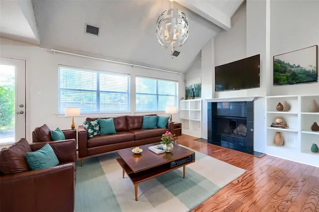 a living room with furniture a flat screen tv and a fireplace