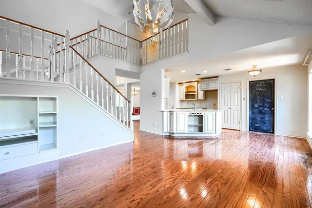a view of an entryway with wooden floor and a kitchen view