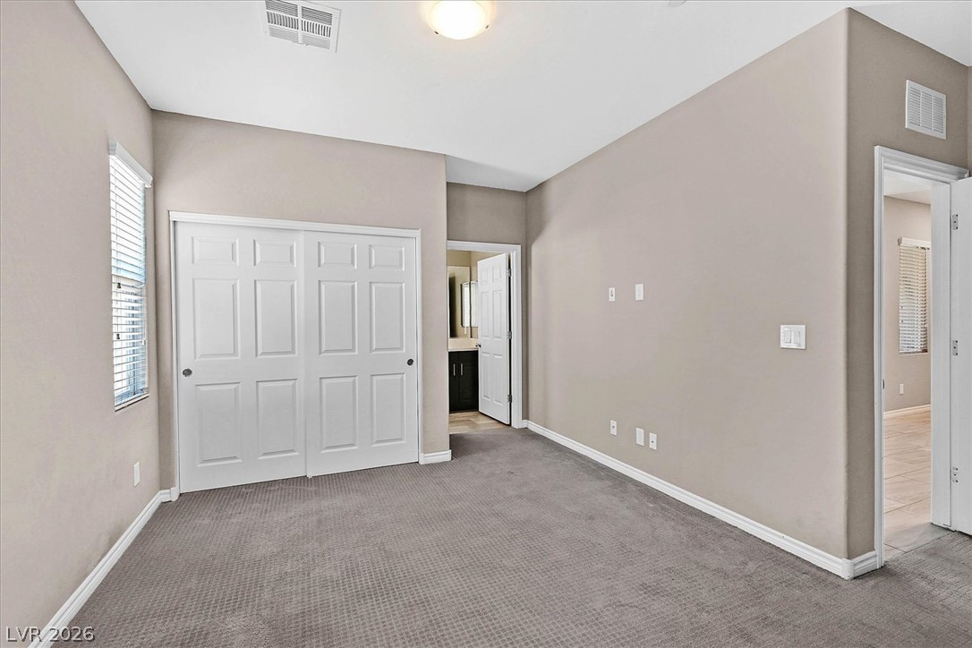 1106 Langston Ranch Avenue Henderson, NV 89002 - Photo 30 of 36 A well-lit bedroom with soft carpet flooring and a spacious closet.