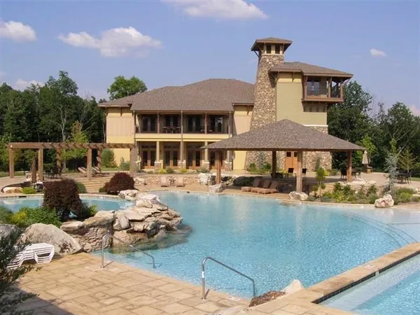 a front view of a house with swimming pool and sitting area