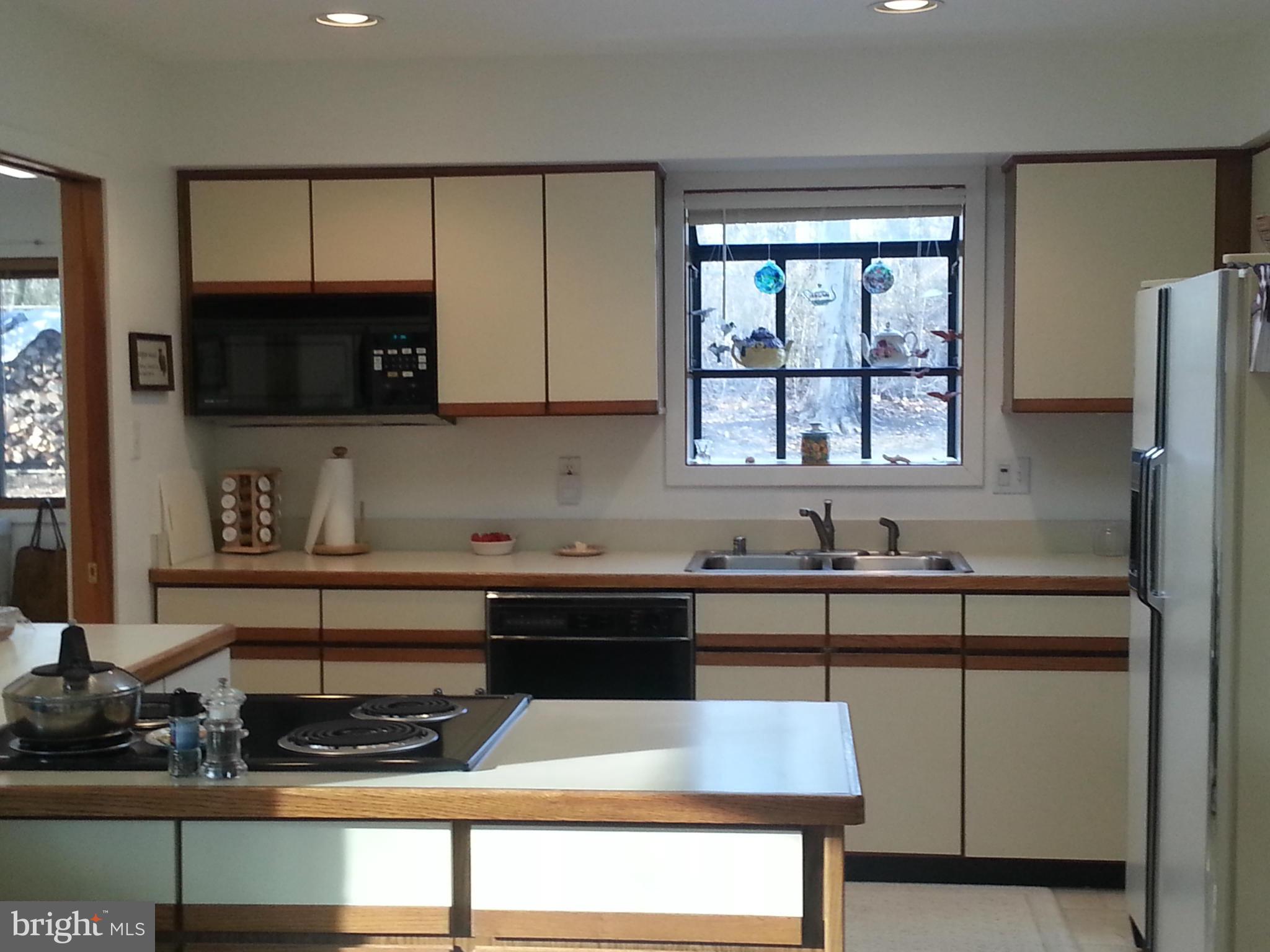 2715 Emmanuel Church Road Huntingtown, MD 20639 - Photo 17 of 28 a kitchen with a sink a microwave and cabinets