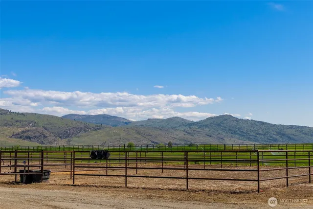 a view of a terrace with a table and chairs under an umbrella next to a yard