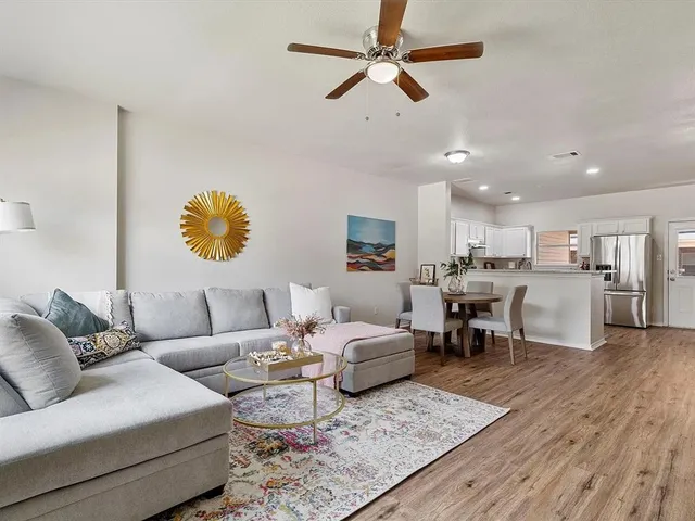 a living room with furniture kitchen view and a chandelier
