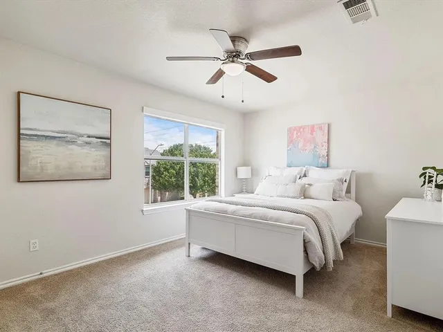 a spacious bedroom with a bed and a window