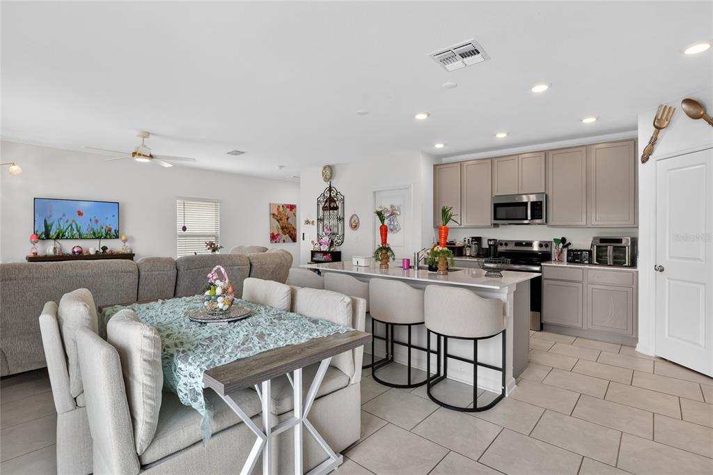 545 Bell Prairie Circle Lake Wales, FL 33859 - Photo 12 of 42 a kitchen with stainless steel appliances granite countertop a stove a sink a dining table and chairs
