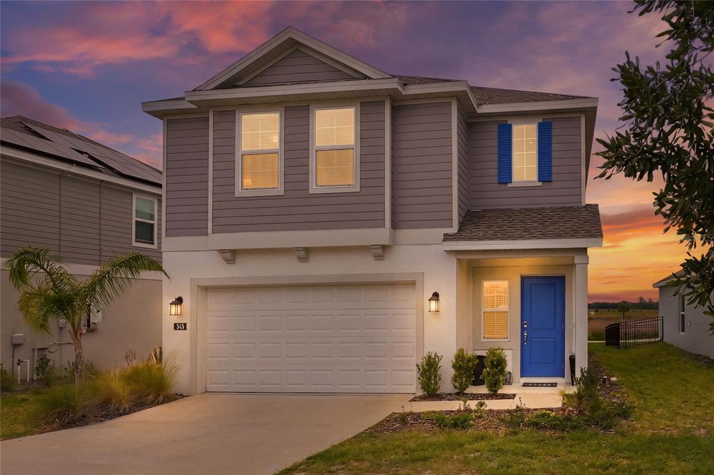 545 Bell Prairie Circle Lake Wales, FL 33859 - Photo 2 of 42 a front view of a house with a yard garage and outdoor seating