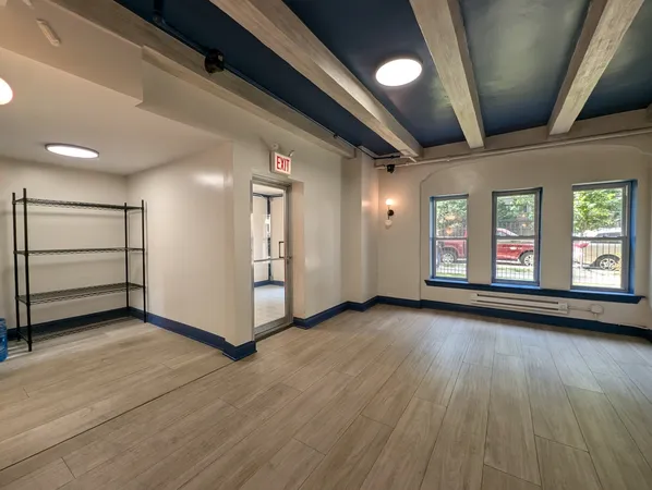 a view of a hallway with wooden floor and entryway