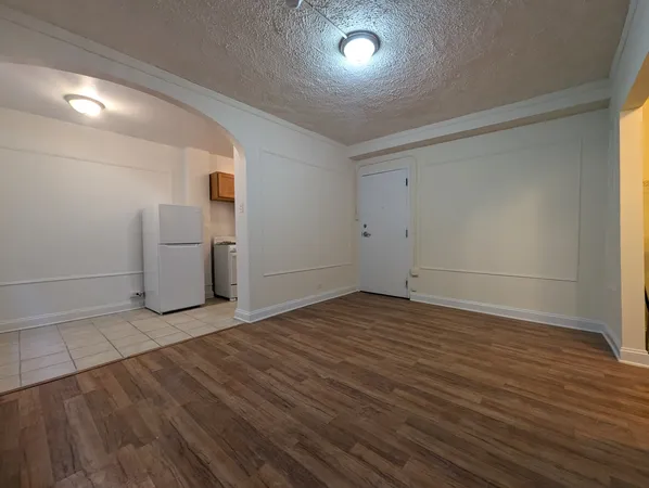 an empty room with wooden floor and white doors