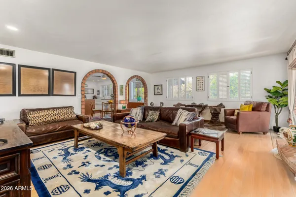 a living room with furniture a rug potted plant and a large window