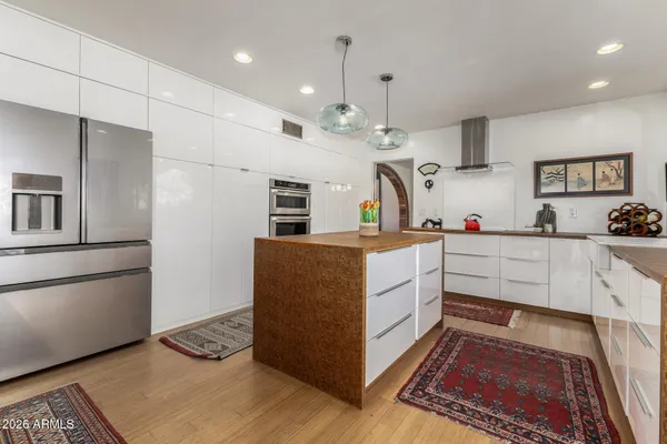 a kitchen with kitchen island a counter space a sink appliances and a counter top space