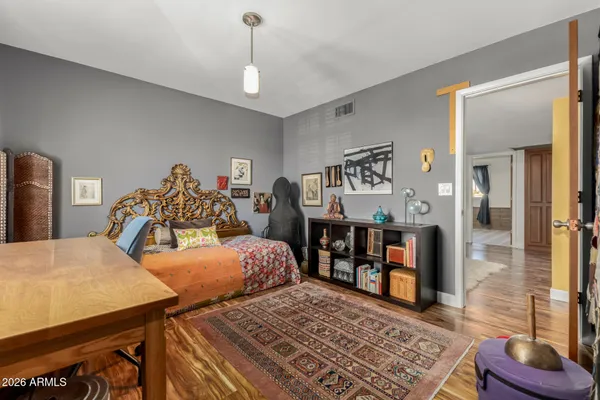 a bedroom with a bed and wooden floor