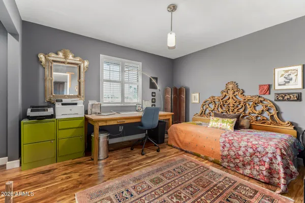 a bedroom with bed table and a window