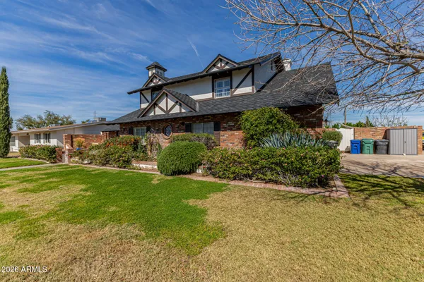 a view of a big house with a big yard and large trees