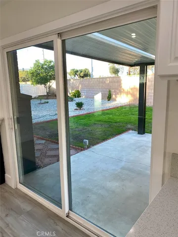 a view of a room that has a bed and wooden floor