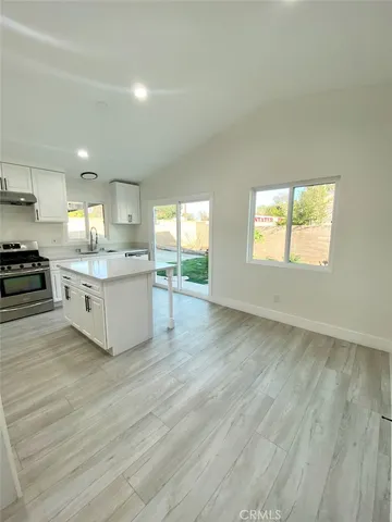 a kitchen with a sink cabinets and wooden floor