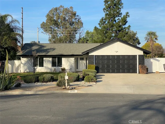 a front view of a house with a yard and potted plants