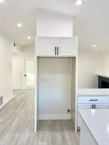 an empty room with wooden floor and a sink