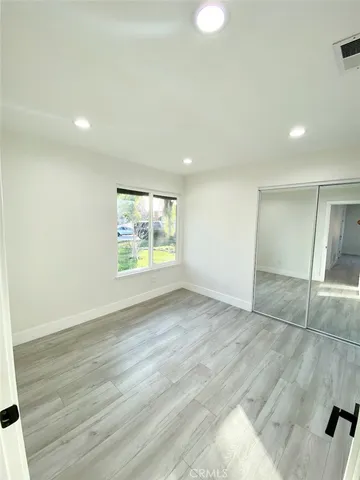 an empty room with wooden floor and entrance