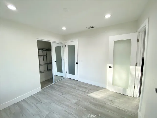 an empty room with wooden floor and sliding door