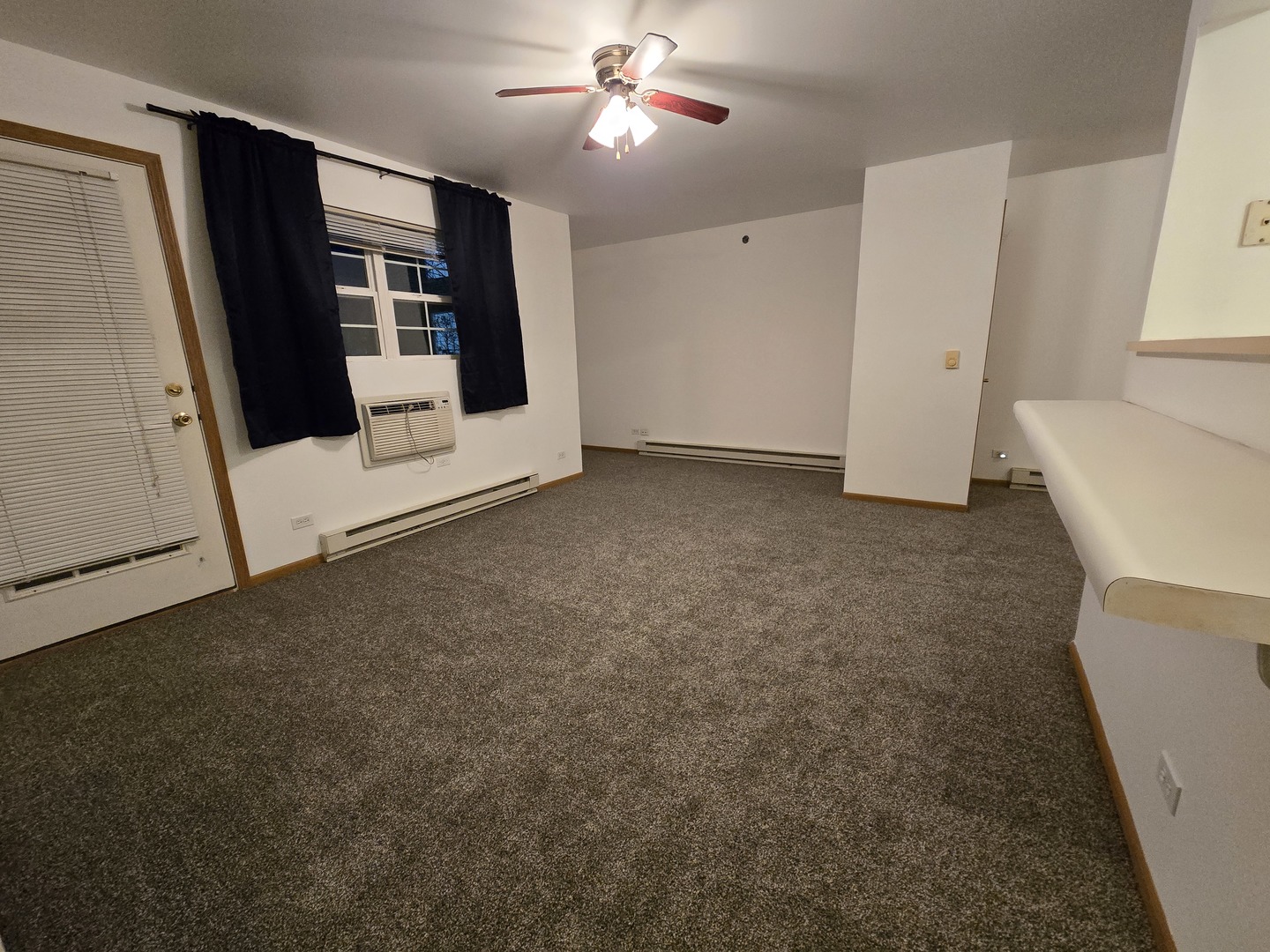 430 Cunat Boulevard, Unit 2A Richmond, IL 60071 - Photo 2 of 13 a view of a livingroom with an empty space and a fireplace