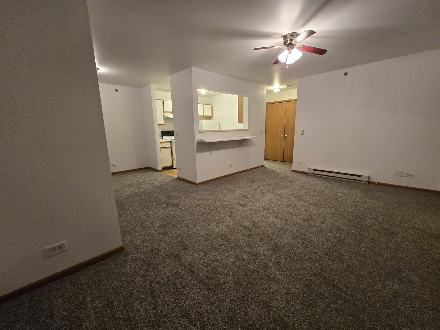 430 Cunat Boulevard, Unit 2A Richmond, IL 60071 - Photo 5 of 13 an empty room with chandelier fan and windows