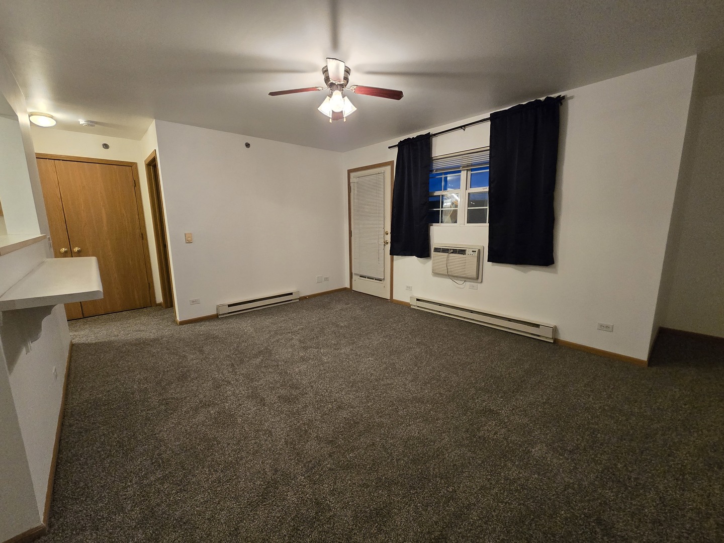 430 Cunat Boulevard, Unit 2A Richmond, IL 60071 - Photo 10 of 13 a view of a livingroom with an empty space and a ceiling fan