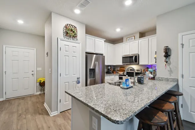 a kitchen with stainless steel appliances granite countertop a sink refrigerator and microwave