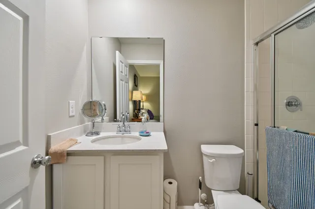 a bathroom with a sink toilet vanity and shower