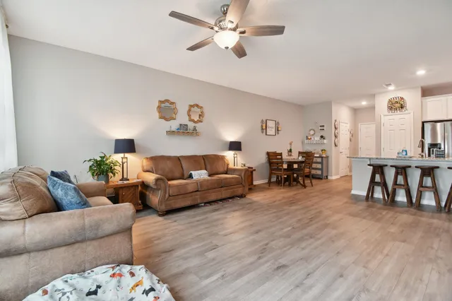 a living room with furniture and a dining table with wooden floor