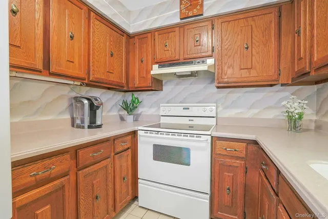 a kitchen with stainless steel appliances granite countertop a sink a stove and cabinets