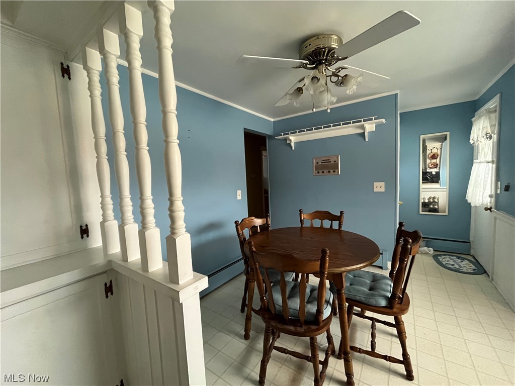 2573 East South Range Road New Springfield, OH 44443 - Photo 12 of 24 Tiled dining room with a baseboard heating unit, ceiling fan, and crown molding