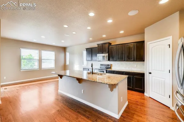 a kitchen with stainless steel appliances granite countertop a sink a stove and a refrigerator
