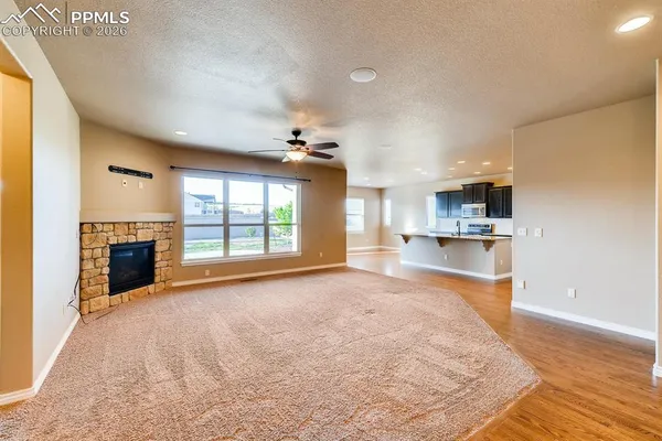 a view of empty room with kitchen and window