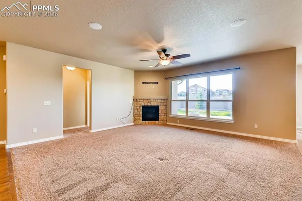 an empty room with windows and fireplace