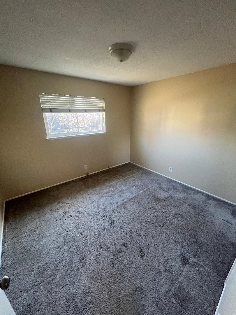 1609 Poppy Way Antioch, CA 94509 - Photo 7 of 10 Carpeted spare room featuring a textured ceiling and baseboards