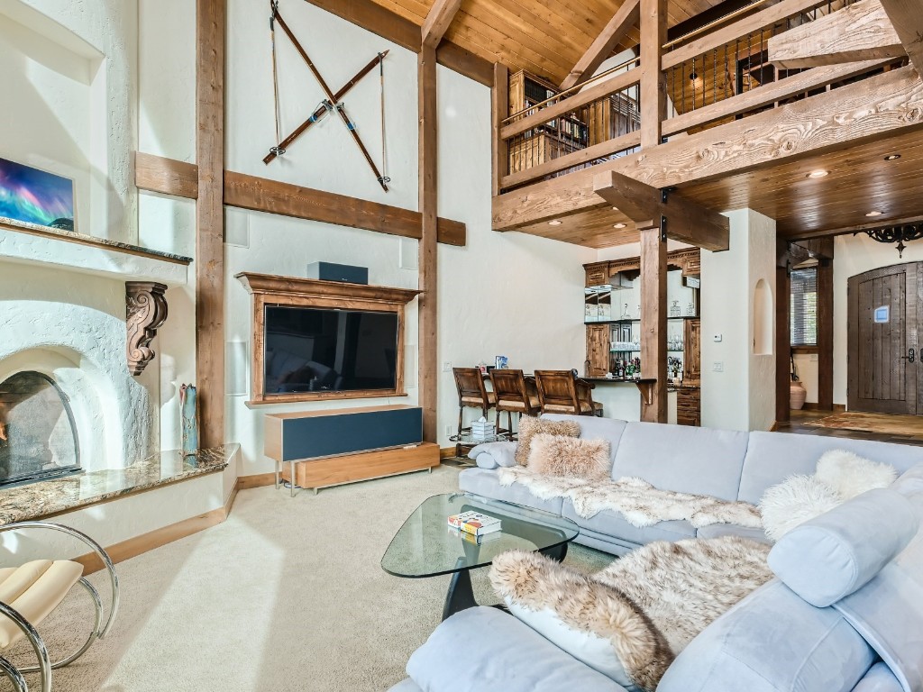 1817 Falcon Drive Silverthorne, CO 80498 - Photo 7 of 37 a living room with furniture a flat screen tv and a floor to ceiling window