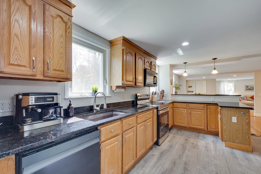 15 Williams Road North Reading, MA 01864 - Photo 6 of 38 a kitchen with stainless steel appliances granite countertop wooden cabinets a sink and dishwasher with wooden floor
