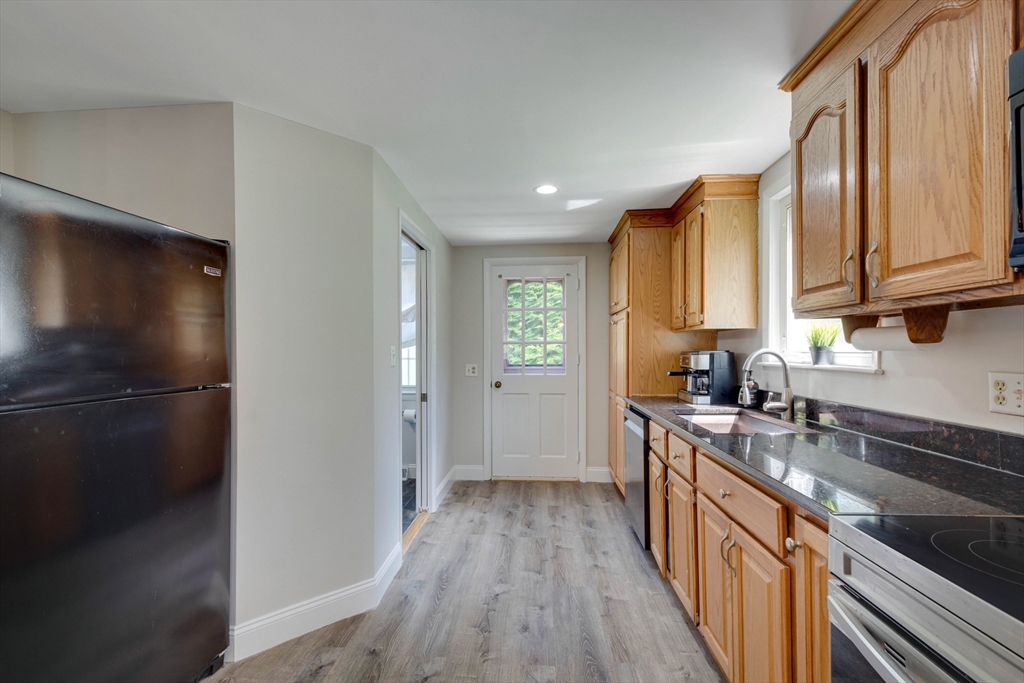 15 Williams Road North Reading, MA 01864 - Photo 8 of 38 a kitchen with stainless steel appliances granite countertop a refrigerator a sink dishwasher a stove and white countertops with wooden floor
