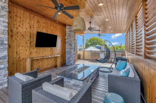 a living room with furniture a flat screen tv and a fireplace