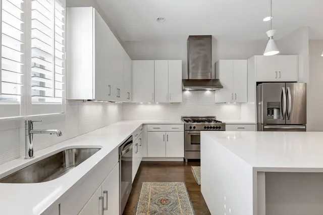 a kitchen with stainless steel appliances kitchen island a sink a stove and refrigerator