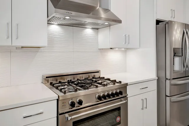 a white stove top oven sitting inside of a kitchen