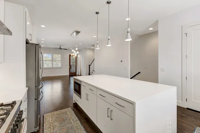 a kitchen with a sink appliances and wooden floor