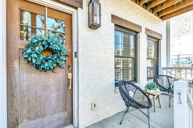 a balcony with table and chairs and potted plants