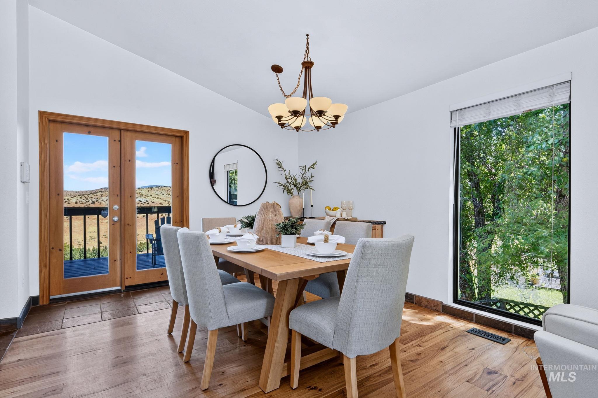 1750 East Shaw Mountain Road Boise, ID 83712 - Photo 13 of 47 Dining area with wood-finish flooring, a contemporary chandelier, and a floor-to-ceiling window