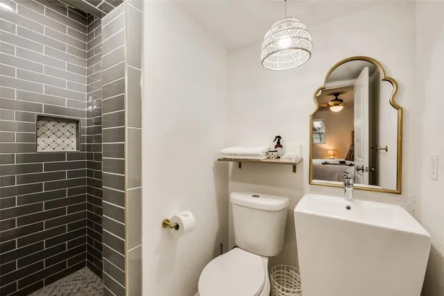 a bathroom with a toilet a sink and mirror