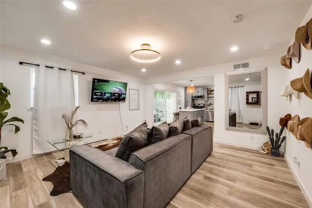 a living room with furniture a flat screen tv and a sink