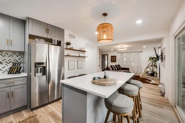 a kitchen with stainless steel appliances granite countertop a dining table and chairs