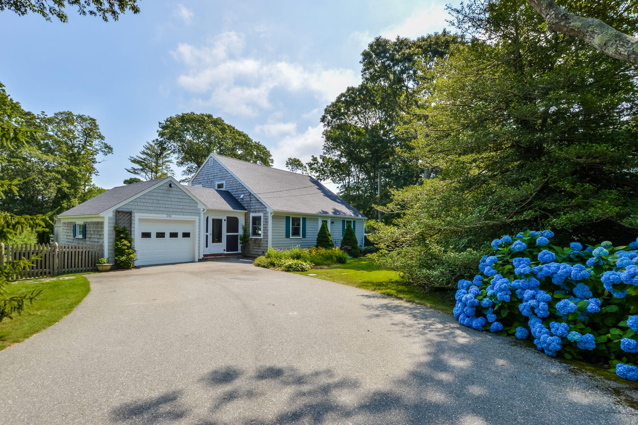 a front view of a house with a yard and trees