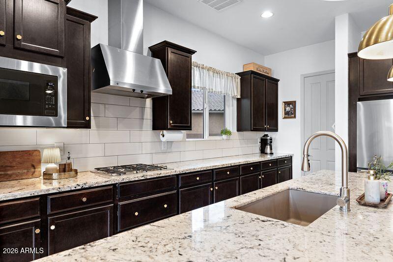 7871 South Stuart Avenue Gilbert, AZ 85298 - Photo 9 of 77 a kitchen with stainless steel appliances kitchen island granite countertop a sink and cabinets