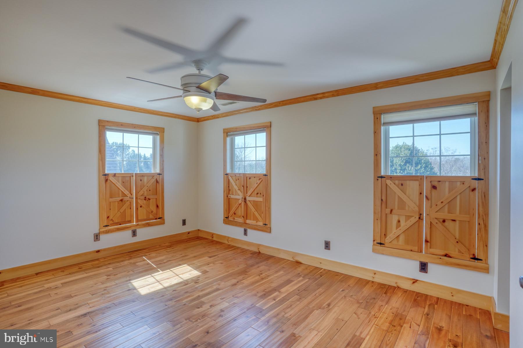 18605 Road 255 Georgetown, DE 19947 - Photo 58 of 93 an empty room with wooden floor chandelier fan and windows